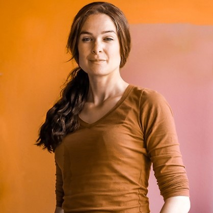 a woman with long hair in a brown shirt